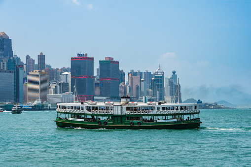 Victoria Harbour, Hong Kong Island, Hong Kong - March 30th 2018: A Star Ferry in the harbour with the skyscrapers of Hong Kong Island in the background.