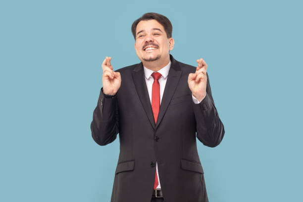istock Smiling satisfied man with mustache standing keeps finger crossed, making wish praying for good luck 1740855234