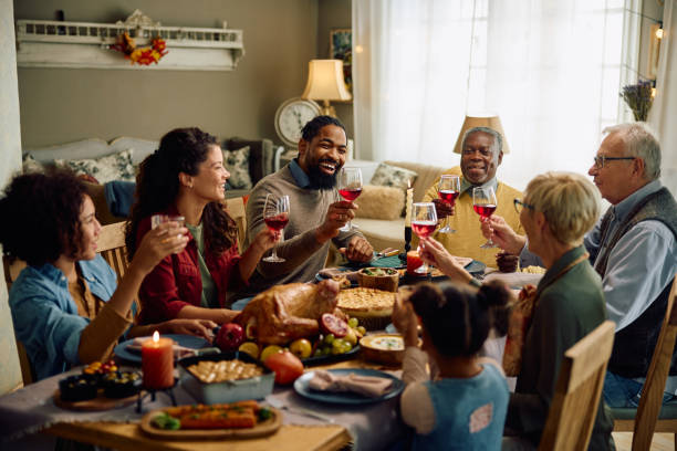 istock Happy multiracial extended family toasting during Thanksgiving meal at dining table. 1740857063
