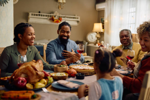 istock Happy black extended family talking during Thanksgiving meal at dining table. 1740862275