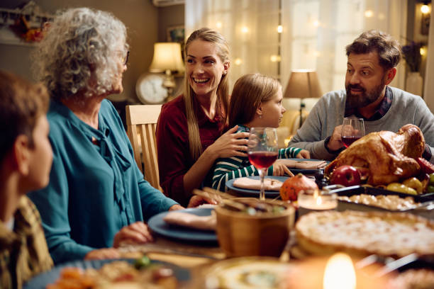 istock Happy extended family talking while having dinner at dining table on Thanksgiving. 1740865599