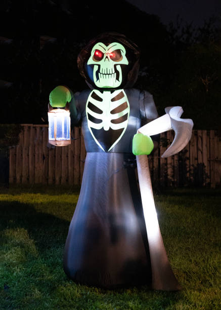 Scary Halloween Skeleton with Glowing Lantern and Scythe stock photo