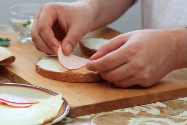 istock Cook's hand decorates the bread and butter with ham 1740884215