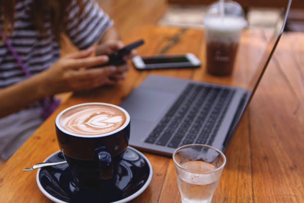 Women using laptop working and drinking coffee cup hot in the morning background
