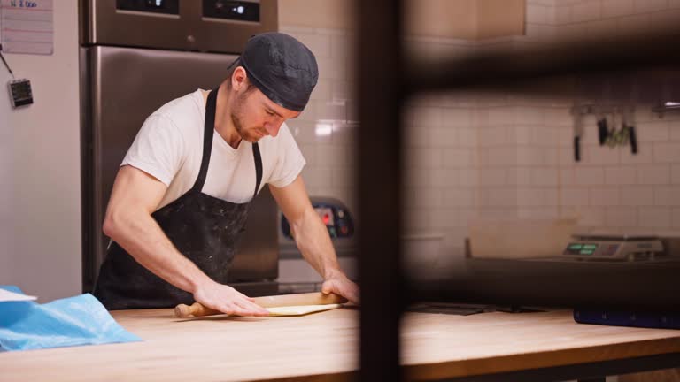 Caucasian Baker Rolling Butter Wrapped In A Baking Paper