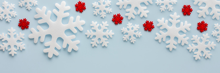 White and red snowflakes on a blue background, Christmas banner, Merry Christmas and Happy New Year concept, top view, copy space