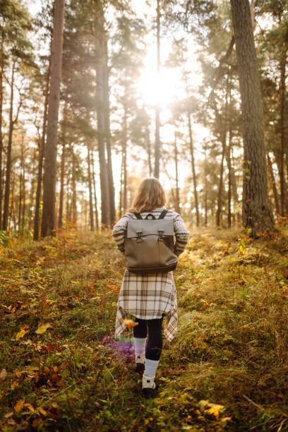 istock Beautiful young tourist with a backpack is having fun in the autumn forest. 1740899227