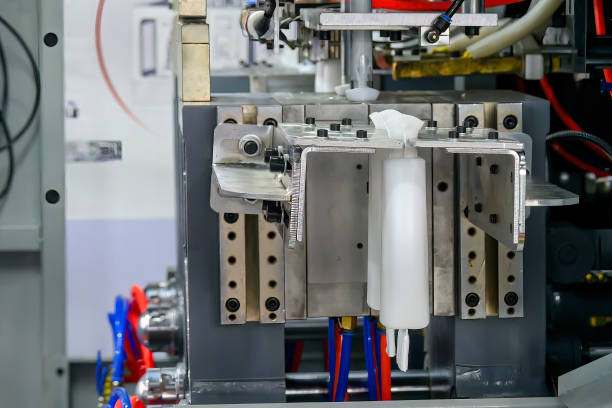 istock The white bottle container manufacturing process by blow mold machine. 1740908915