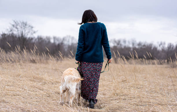 istock Woman walking dog on leash 1740913008