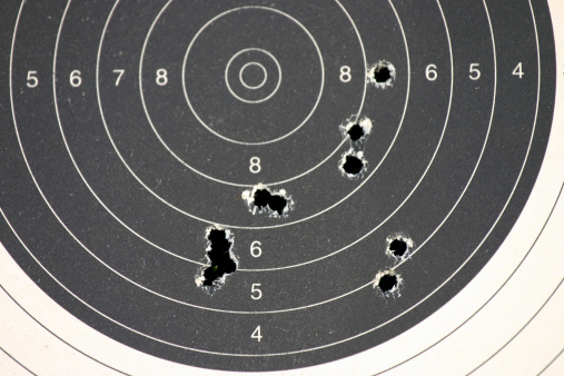paper target with bullet holes from the gun range