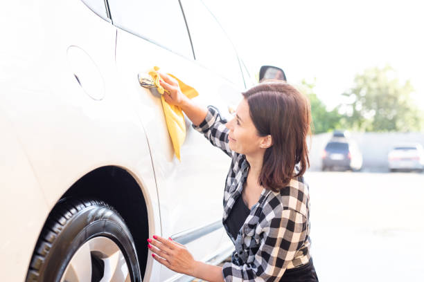 istock Woman wiping car with rag 1740915280