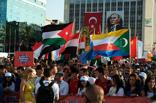 Izmir, Turkey - September 1, 2023: Crowds gather in Izmir with flags of various nations. Mayor TunÃ§ Soyer is seen mingling with attendees during the event. Unity and diversity shine bright