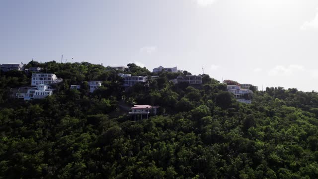 Stunning aerial view homes on mountain st. thomas coki beach sapphire beach turquoise water waves blue sky white clouds east end red hook hills and mountains sun gleaming