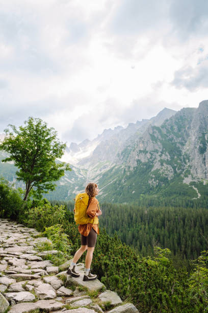 istock Smiling traveler with a bright backpack on a hiking mountain trail. 1740939609