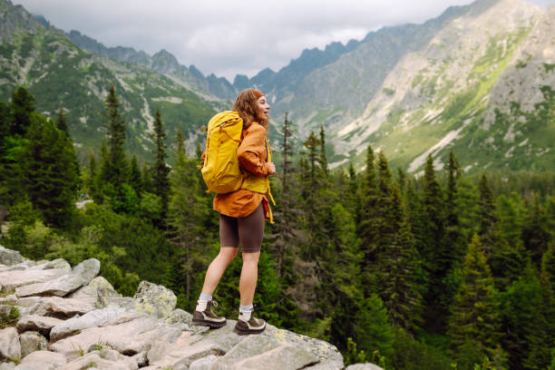 istock Smiling traveler with a bright backpack on a hiking mountain trail. 1740939974