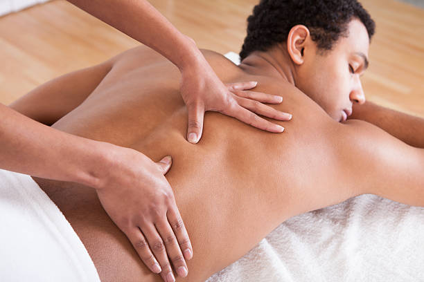 Man Receiving Massage From Female Hand Portrait Of Man Receiving Massage Treatment From Female Hand black male massage stock pictures, royalty-free photos & images