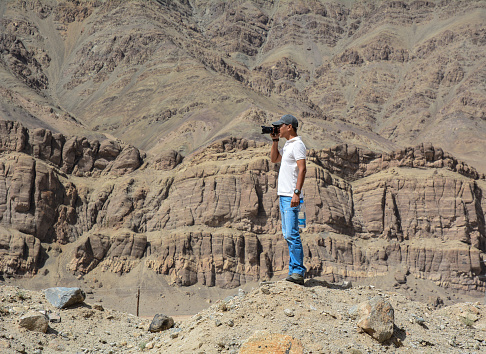 Ladakh, India - Jul 19, 2015. A young man stands on mountain in Ladakh, North of India.
