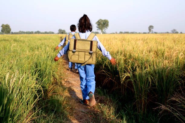 Elementary age school students walking on country road
