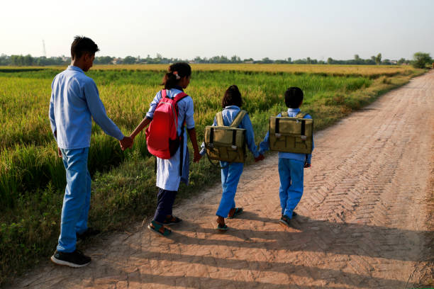 istock Elementary age school students walking on country road after school vacation 1740995350