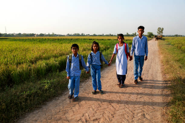 istock Elementary age school students walking on country road after school vacation 1740995875