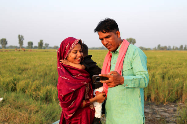 istock Indian family using mobile phone near green field 1740997039