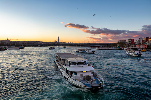 Istanbul, Turkey - Oct 25, 2018:Passenger ships in Golden Horn near Galata bridge in an cloudy day. The Galata Bridge is a bridge that spans the Golden Horn.