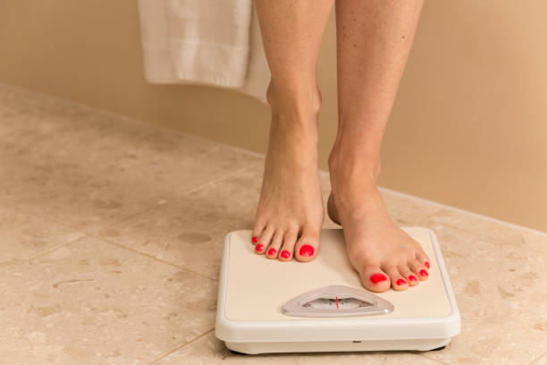 istock Healthy Lifestyle: Woman stepping on scale. Weight loss. Dieting. 174102232