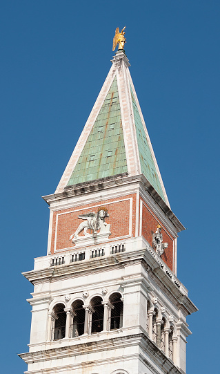 Piazza San Marco with top of Campanile di San Marco with golden angel on top at City of Venice on a sunny summer day.