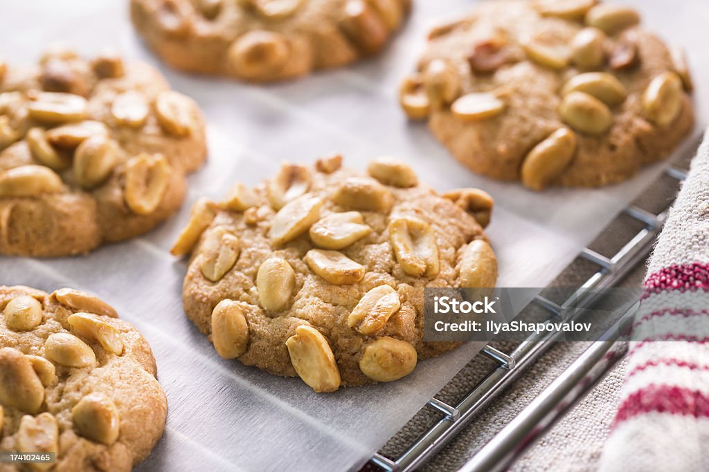 A close up photograph of some peanut chip cookies Warm, golden brown, peanut chip cookies cooling on a backing rack. Bakeware Stock Photo