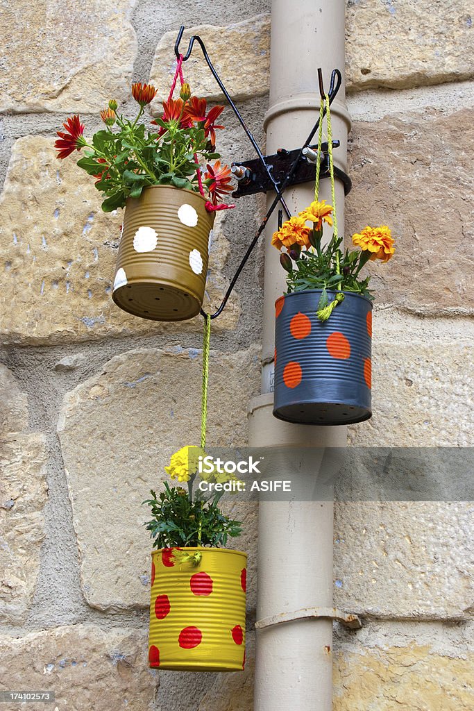 Hanging flowerpots made with cans. Hanging flowerpots made with cans in the street. Can Stock Photo