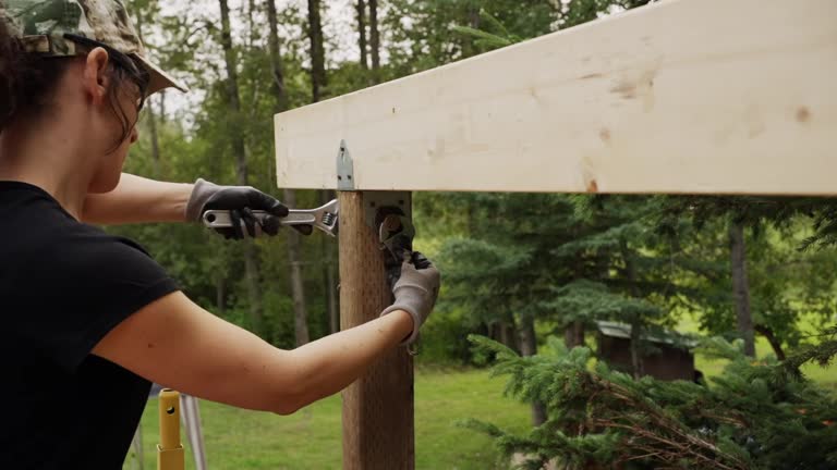 Time lapse of a woman attaching a roof beam to a wooden deck