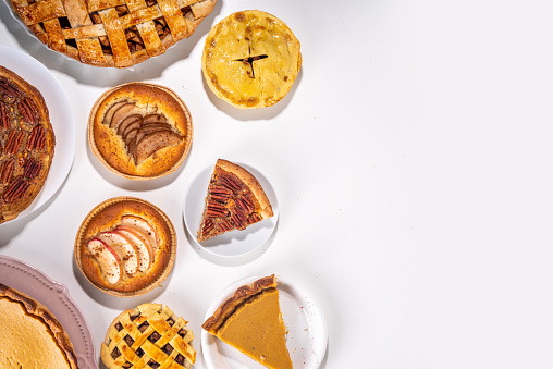 Assorted homemade fall cakes. Traditional autumn american european pumpkin, apple and pecan pie. Thanksgiving family dinner, seasonal homemade baking and pastry background on white table