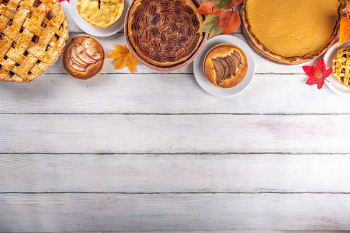 Assorted homemade fall cakes. Traditional autumn american european pumpkin, apple and pecan pie. Thanksgiving family dinner, seasonal homemade baking and pastry background on wooden table