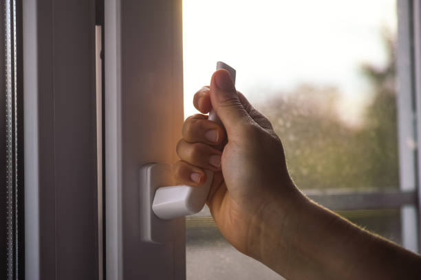 A woman opening a window. stock photo