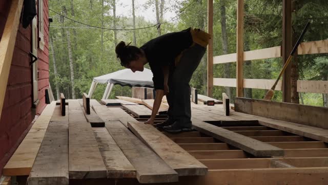 Time lapse of a woman laying planks down on a deck frame