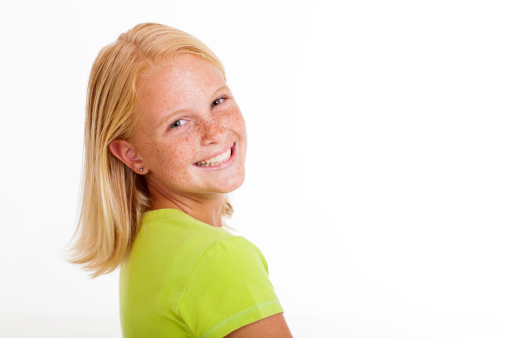 Close up of a standing young blond woman in plain red shirt on white background