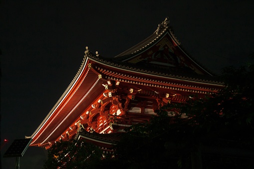 A majestic traditional Japanese building illuminated by glowing lights in the evening sky in Kyoto
