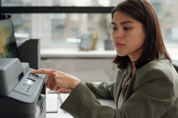 istock Young brunette businesswoman in grey blazer pressing button on panel 1741050743