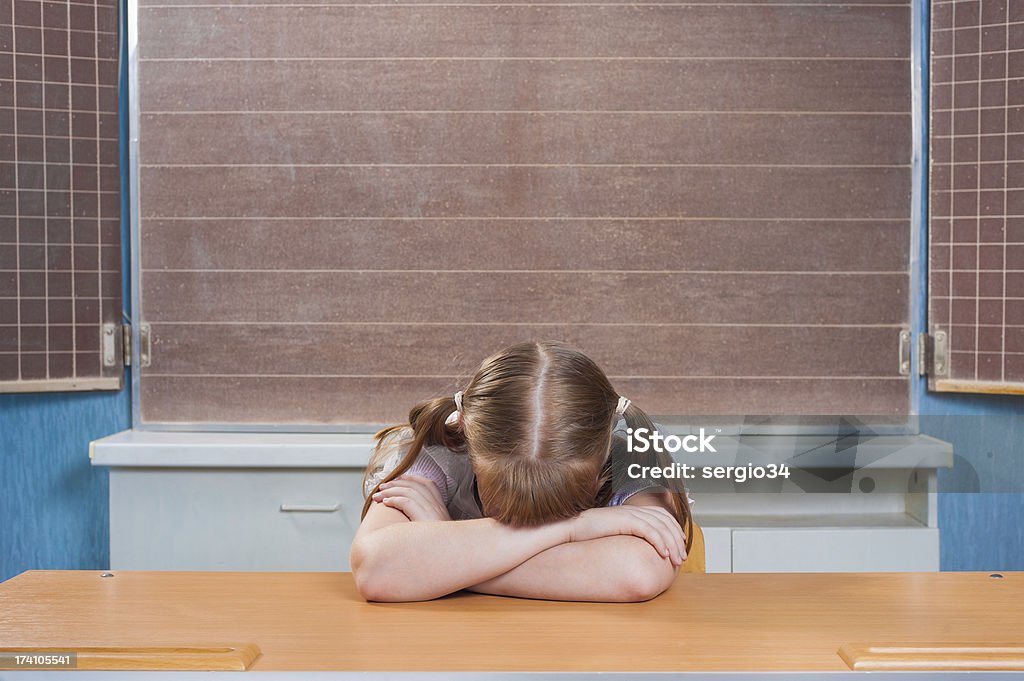 Schoolgirl in a classroom Portrait of a cute schoolgirl in a classroom Adolescence Stock Photo