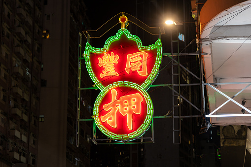 Hong Kong - October 17, 2023 : Tong Fung Pawn Shop sign in Wan Chai, Hong Kong. The iconic neon green and red signs can be seen in most of Hong Kong's 18 districts, they are some of the oldest businesses in Hong Kong.