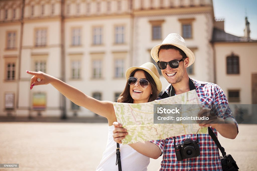 Happy tourist sightseeing city with map Happy tourist sightseeing city with map  Couple - Relationship Stock Photo