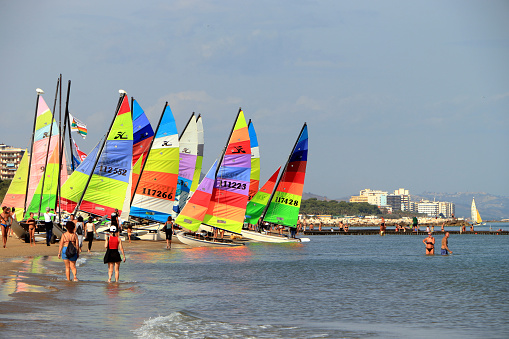 Pescara, Sunday 15 October 2023. On the exceptionally warm autumn day, with a peak of 31°C, the photo shows people walking on the beach and in the water, while a small fleet of catamarans is ready to set sail for a regatta.