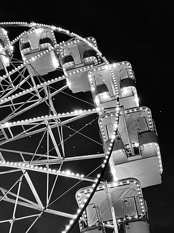 Looking up at an illuminated Ferris wheel