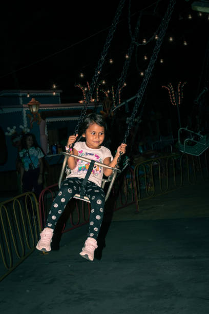 Girl playing in Diverland amusement park attractions, Margarita, Nueva Esparta, at night