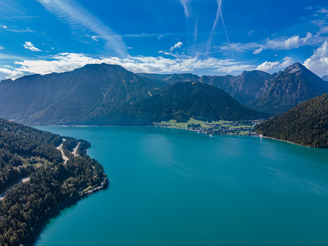 Aerial view of the beautiful Achen Lake in Tyrol, Austria. Photography of the lake was shoot from a drone at a higher altitude, in mid day on a sunny weather, with the mountains in the background.