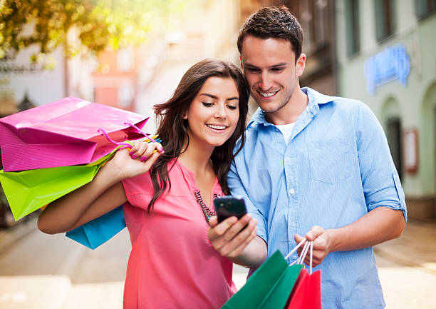 istock Young couple with shopping bag using mobile phone 174108231
