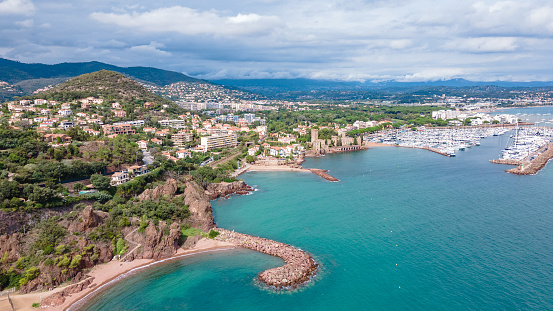 Aerial view of Mount Turnei, located on the French Riviera. Photography was shot from a drone at a higher altitude from above the water wit the beautiful marina and beach in the view.