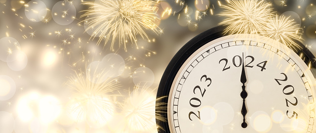 Classic clock with clock hands on year 2024. New Years eve celebration with fireworks on blurred lights background. Copy space.