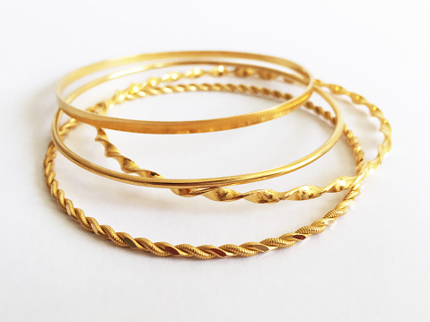 Gold bracelets on white background