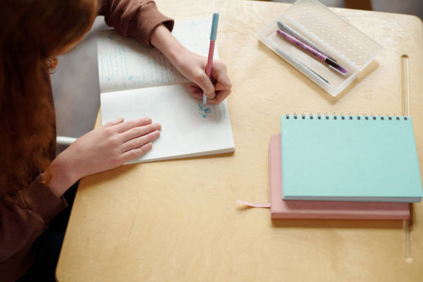 istock Above angle of hands of secondary school learner drawing in copybook 1741110992